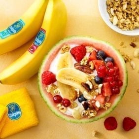 Fruit salad in a watermelon, stuffed with organic yogurt, Chiquita bananas, red fruit, seeds and nuts